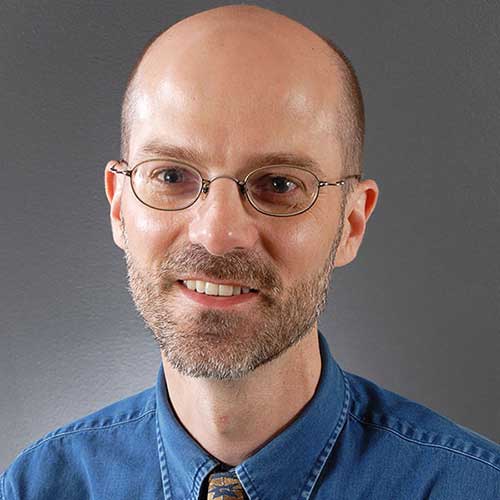 a man wearing glasses and looking at the camera