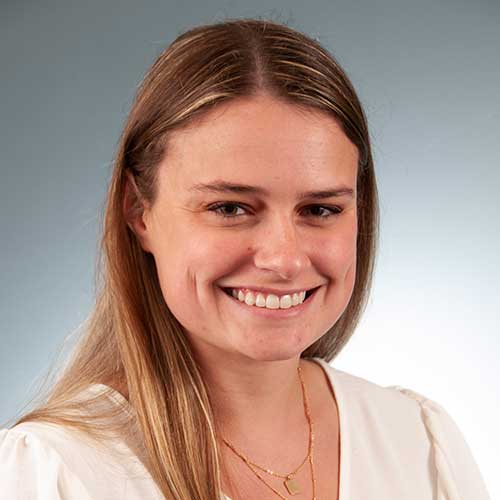 a woman wearing glasses and smiling at the camera