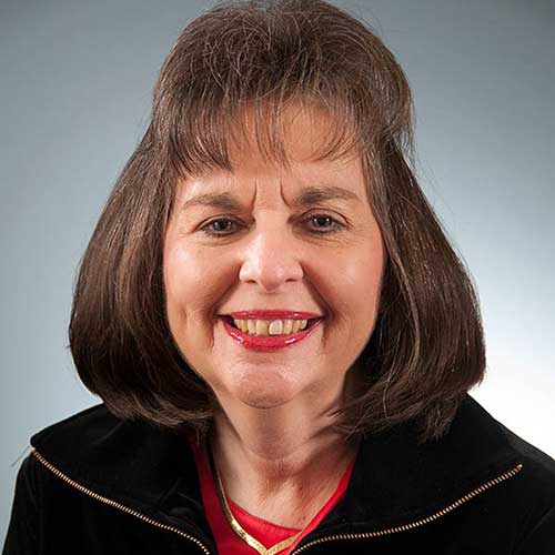 a close up of a woman who is smiling and looking at the camera