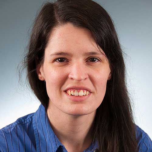 a person wearing a blue shirt and smiling at the camera