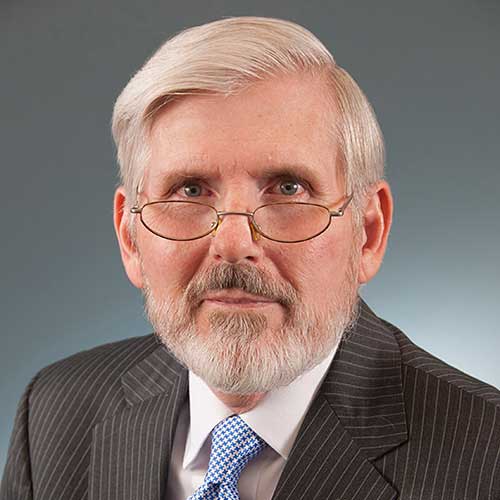 C. Robert Cloninger wearing glasses and a suit and tie