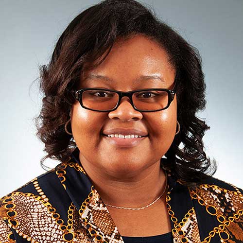 a woman wearing glasses and smiling at the camera