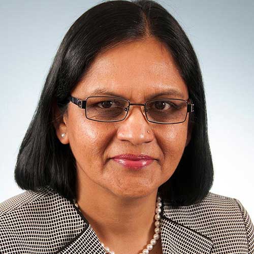 a woman wearing glasses and smiling at the camera