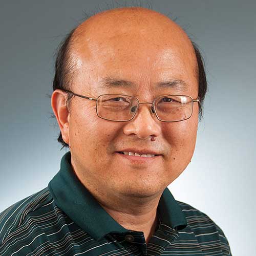 a man wearing glasses and smiling at the camera