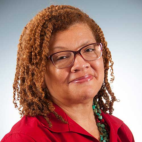 a woman wearing glasses and smiling at the camera