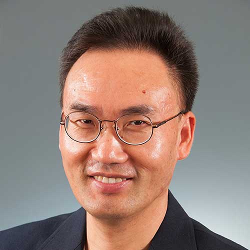 a man wearing glasses and smiling at the camera