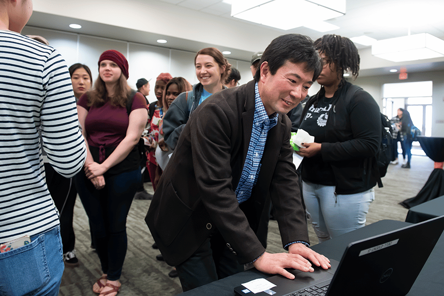 a group of people looking at a laptop