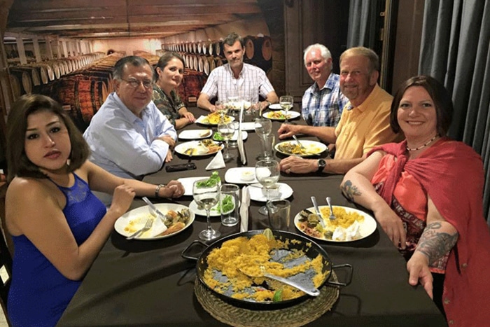 a group of people sitting at a table with a plate of food