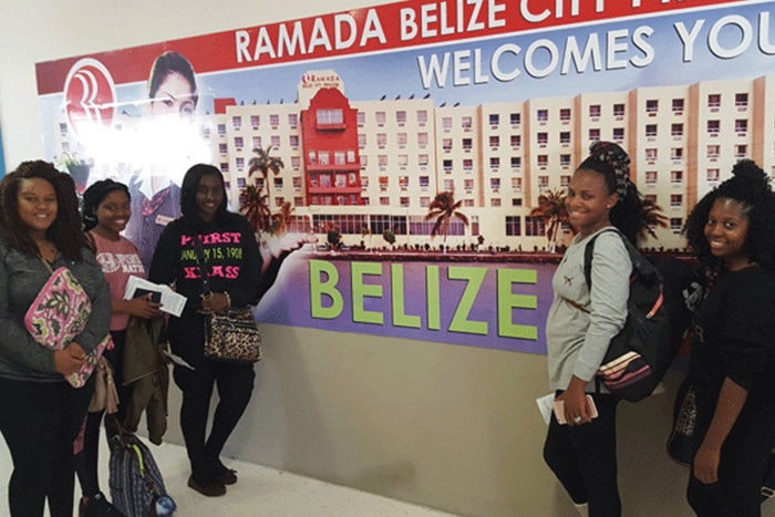 a group of people standing in front of a sign a group of people standing in front of a sign
