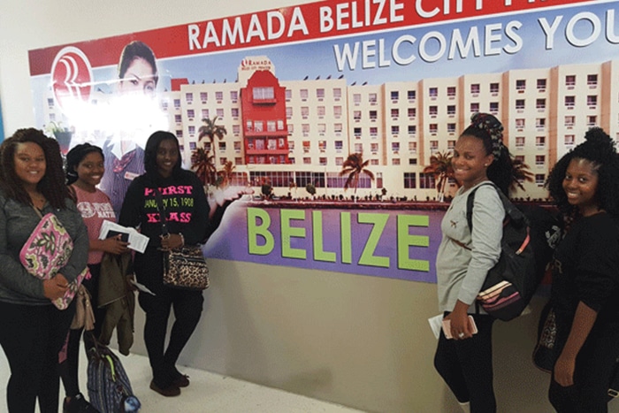 a group of people standing in front of a sign