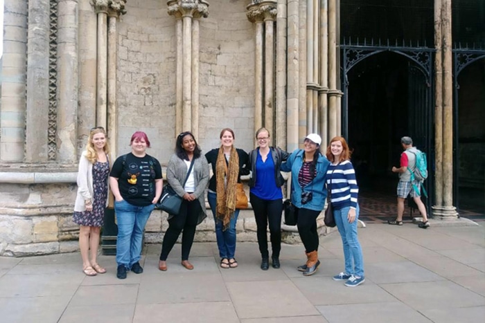 a group of people standing in front of a building a group of people standing in front of a building