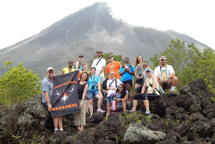 a group of people standing on a rocky hill