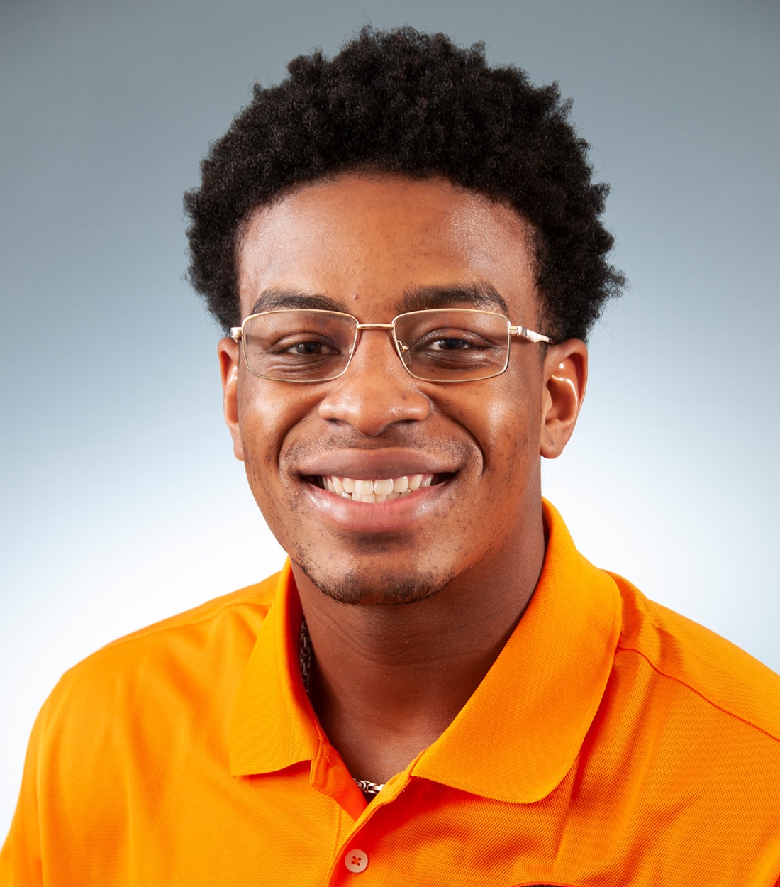 a man wearing glasses and smiling at the camera