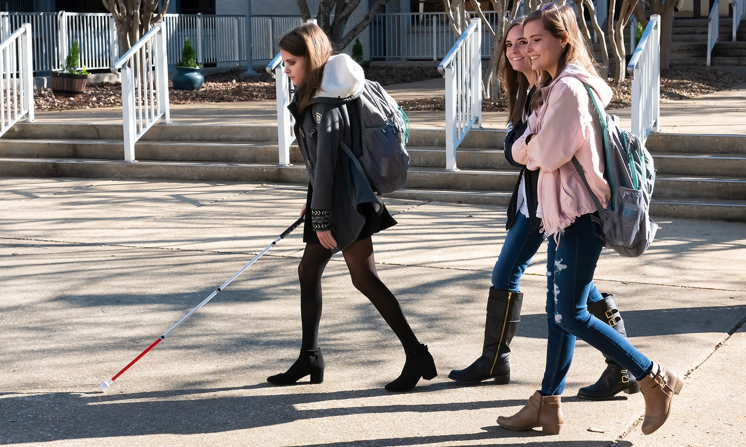 a person is walking down the street students walking across campus