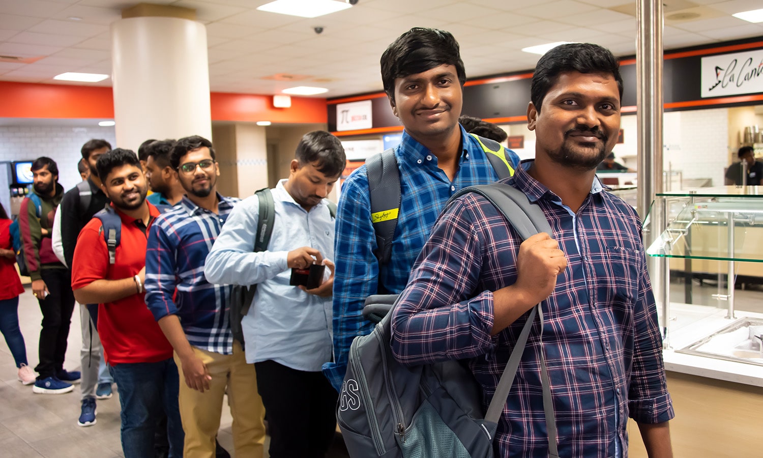 a man standing in front of a group of people posing for the camera