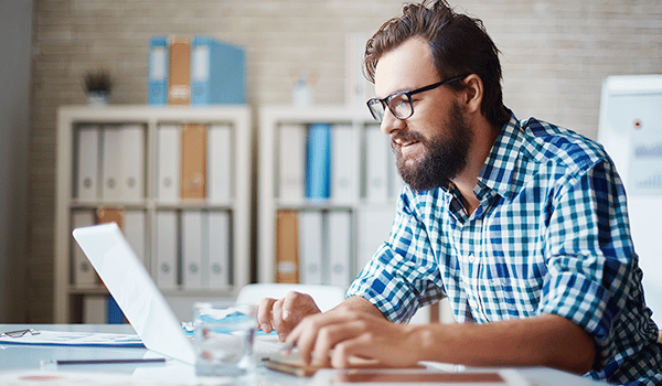 a man sitting at a table using a laptop