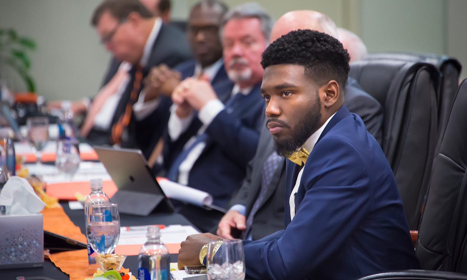 a man sitting at a table looking at a laptop