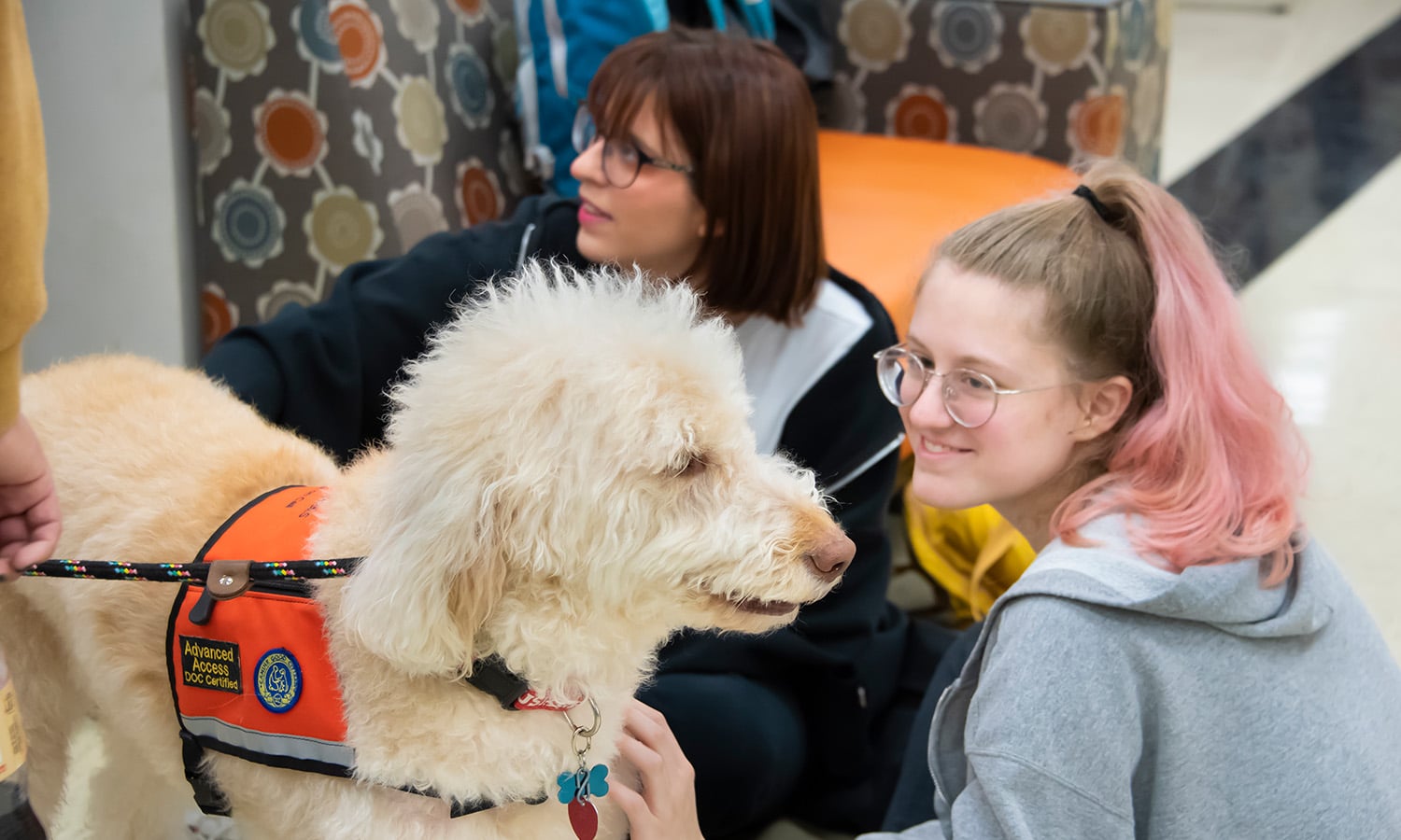 two students with a service dog