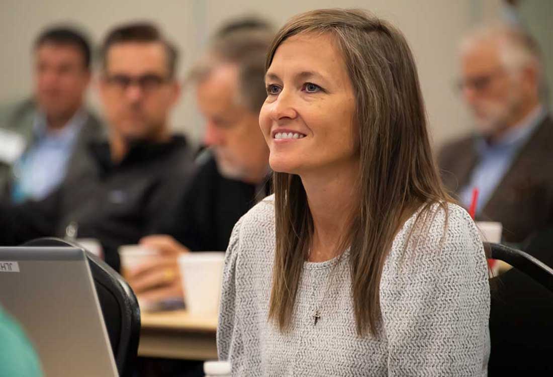 AUM student smiles during classroom lecture at Auburn University at Montgomery, engaged in learning with peers.