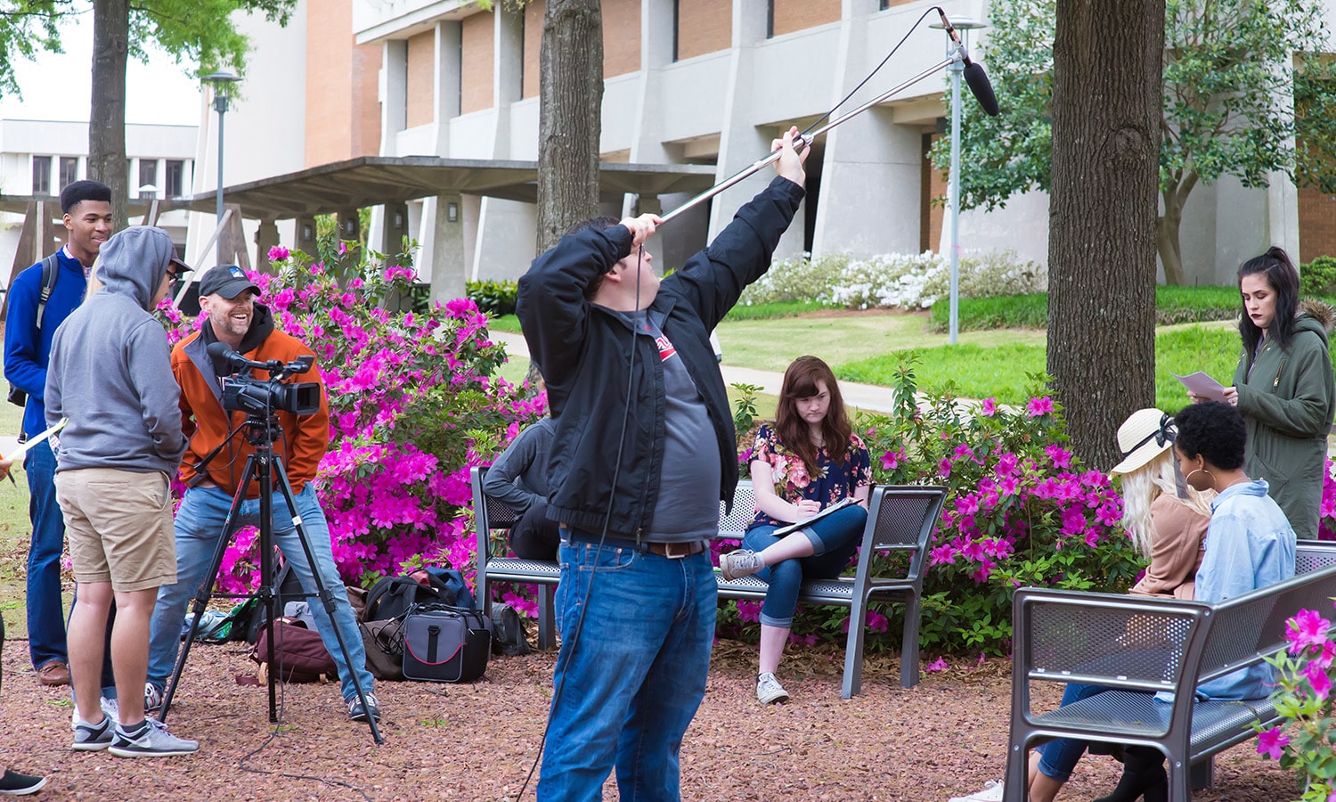 a group of people making a movie in a park