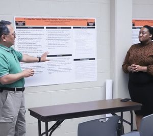 A Group Of People Standing In Front Of A Computer