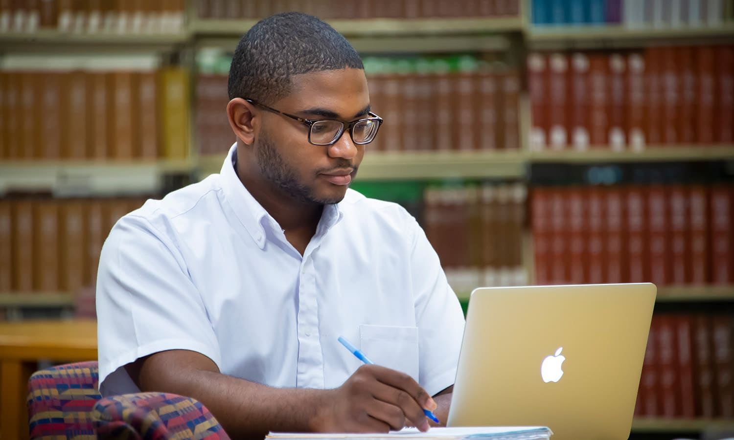 a man sitting at a table using a laptop computer