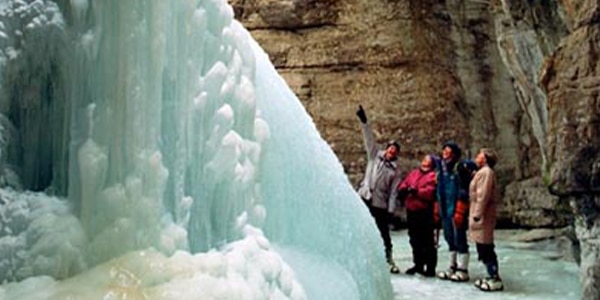 a group of people on a rock in the snow