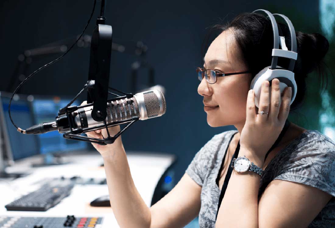 Auburn University at Montgomery communications student in a campus radio studio speaking into a microphone with headphones