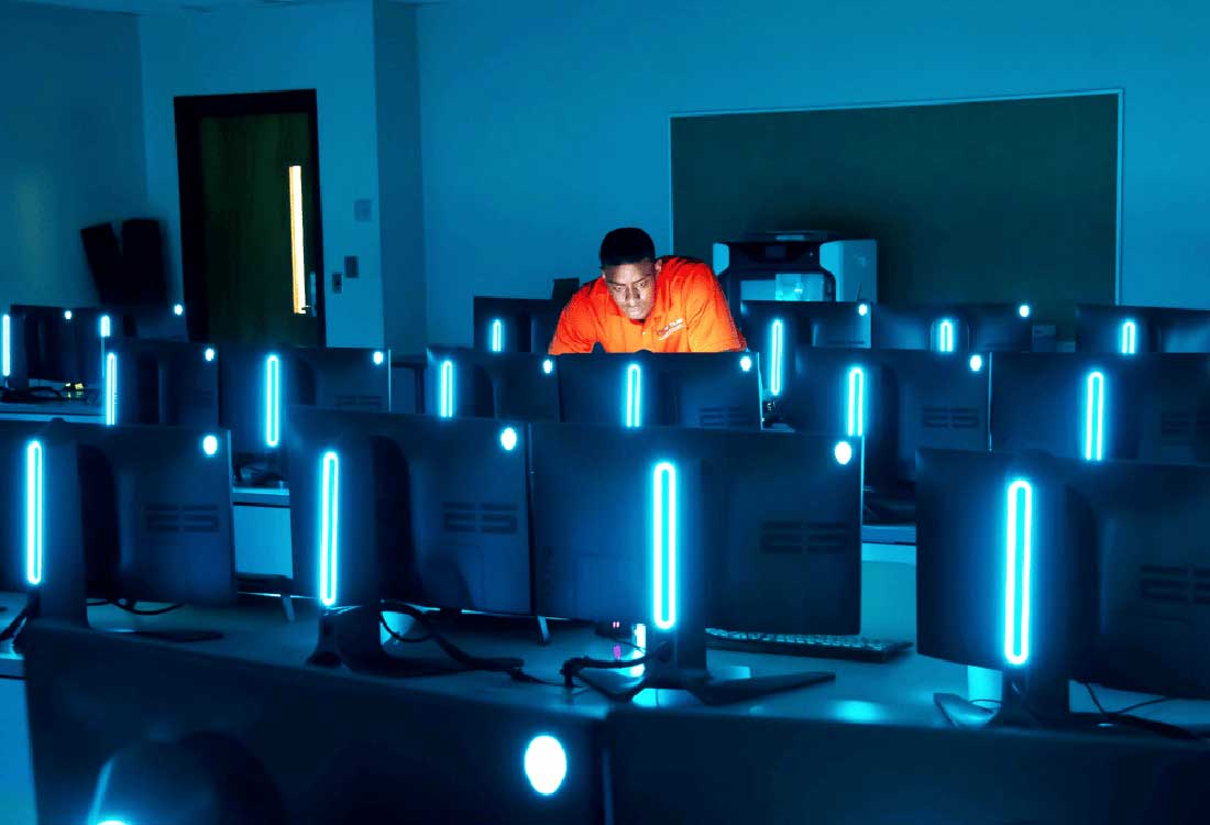 AUM computer science student works in high-tech campus lab with glowing monitors at Auburn University at Montgomery.