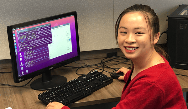 a young boy sitting at a desk with a computer monitor and keyboard