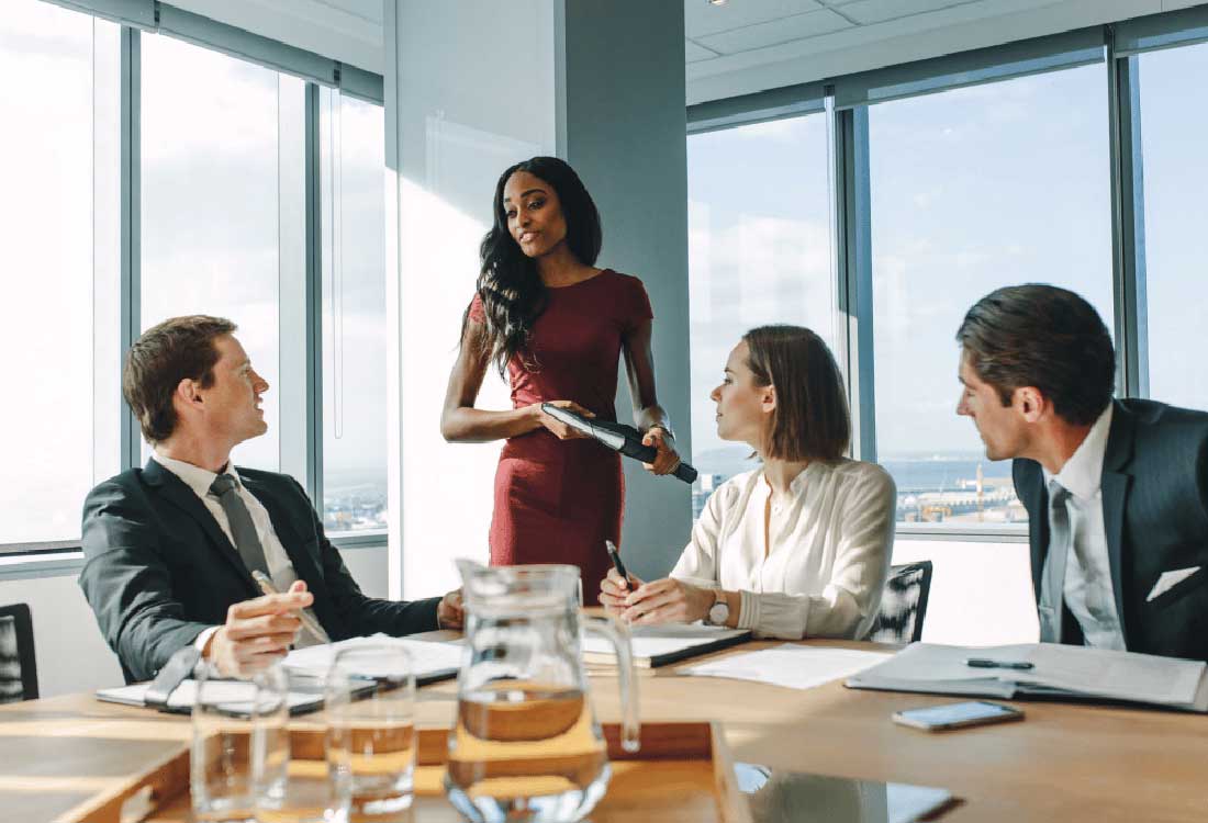 Auburn University at Montgomery business leadership: a woman presents to colleagues during a conference room meeting