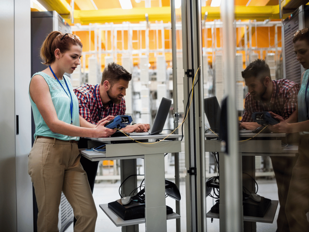 a man and a woman standing in front of a computer