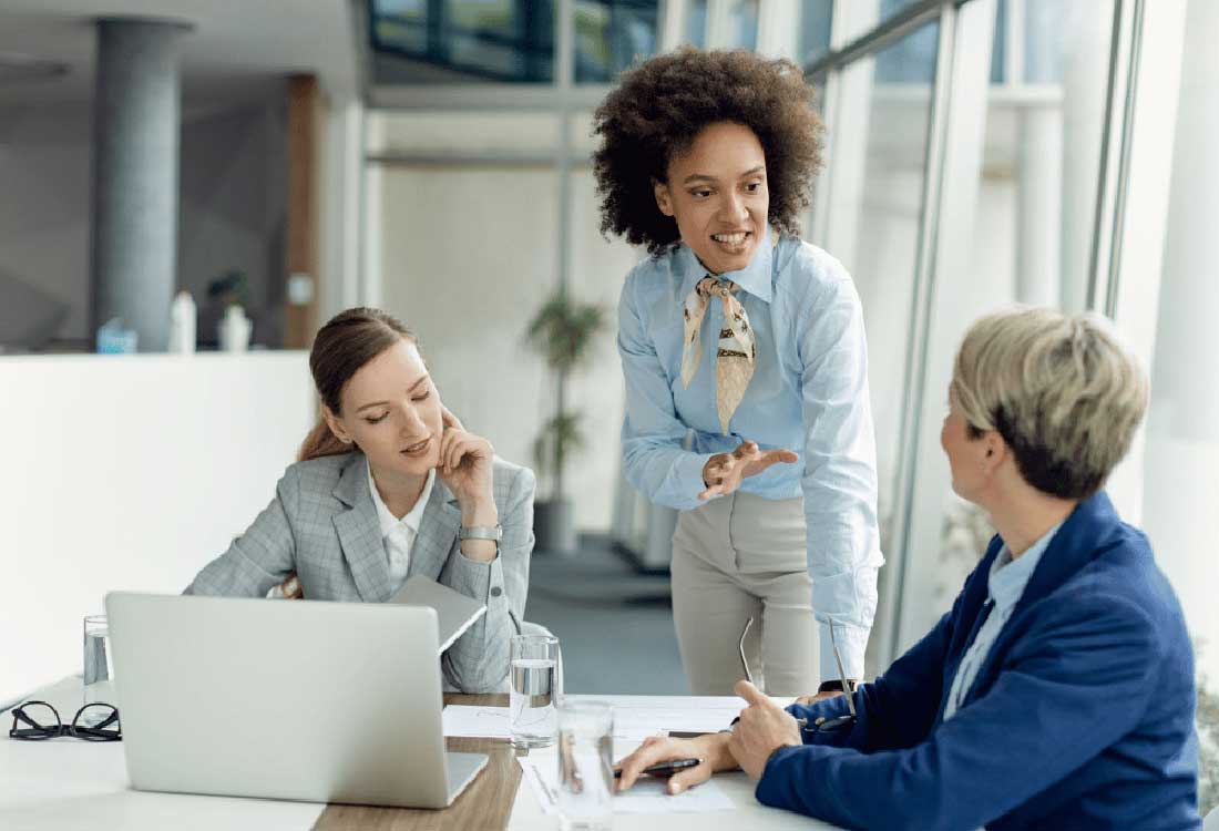 Auburn University at Montgomery business team: three women collaborating on a project in a modern office