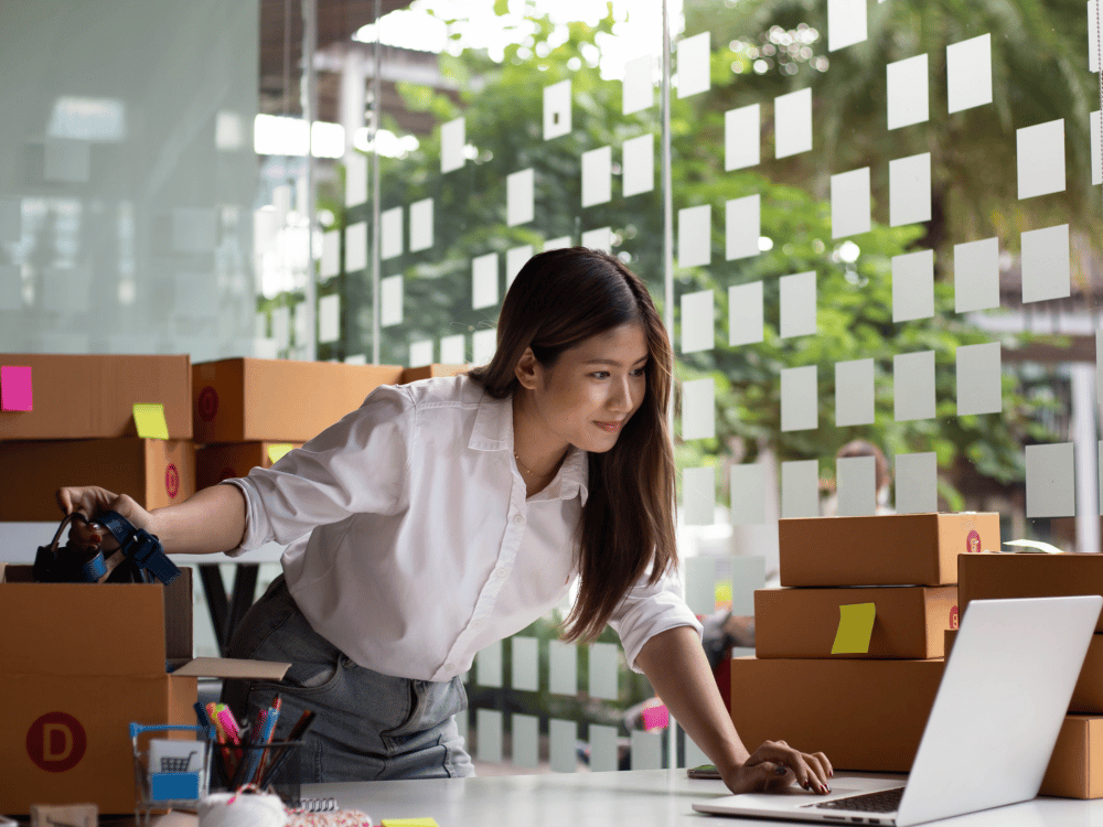 a woman standing in front of a laptop