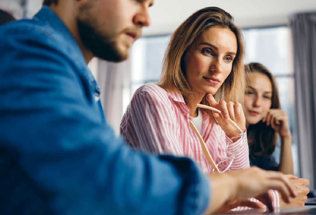 AUM students collaborating in class, a woman in pink listens during group work at Auburn University at Montgomery