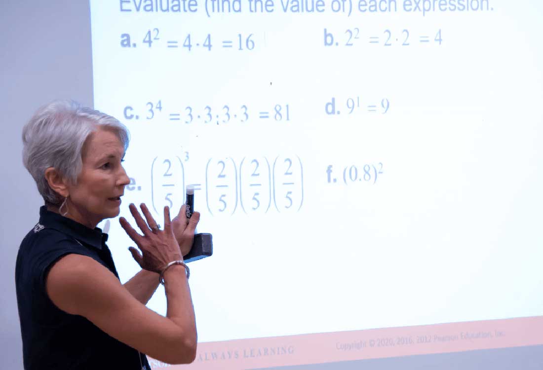 Auburn University at Montgomery professor teaches exponents and fractions on projector in math class.