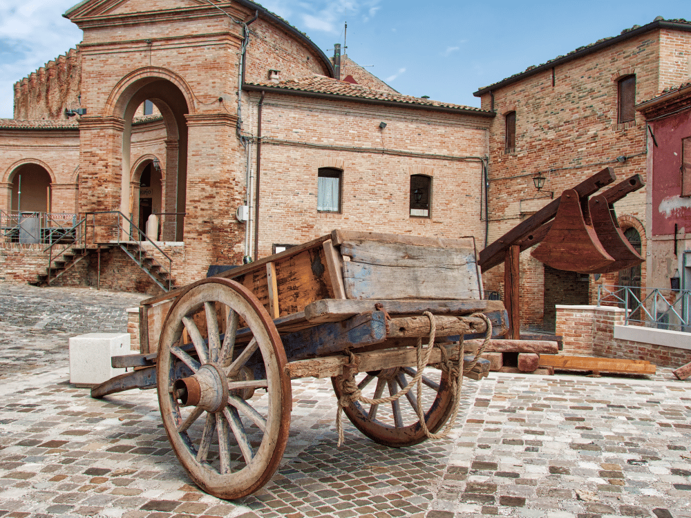 a stone building that has a bench in front of a brick wall