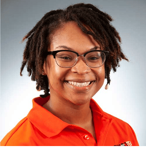 a person wearing glasses and smiling at the camera