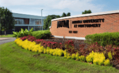 a large brick building with grass and trees