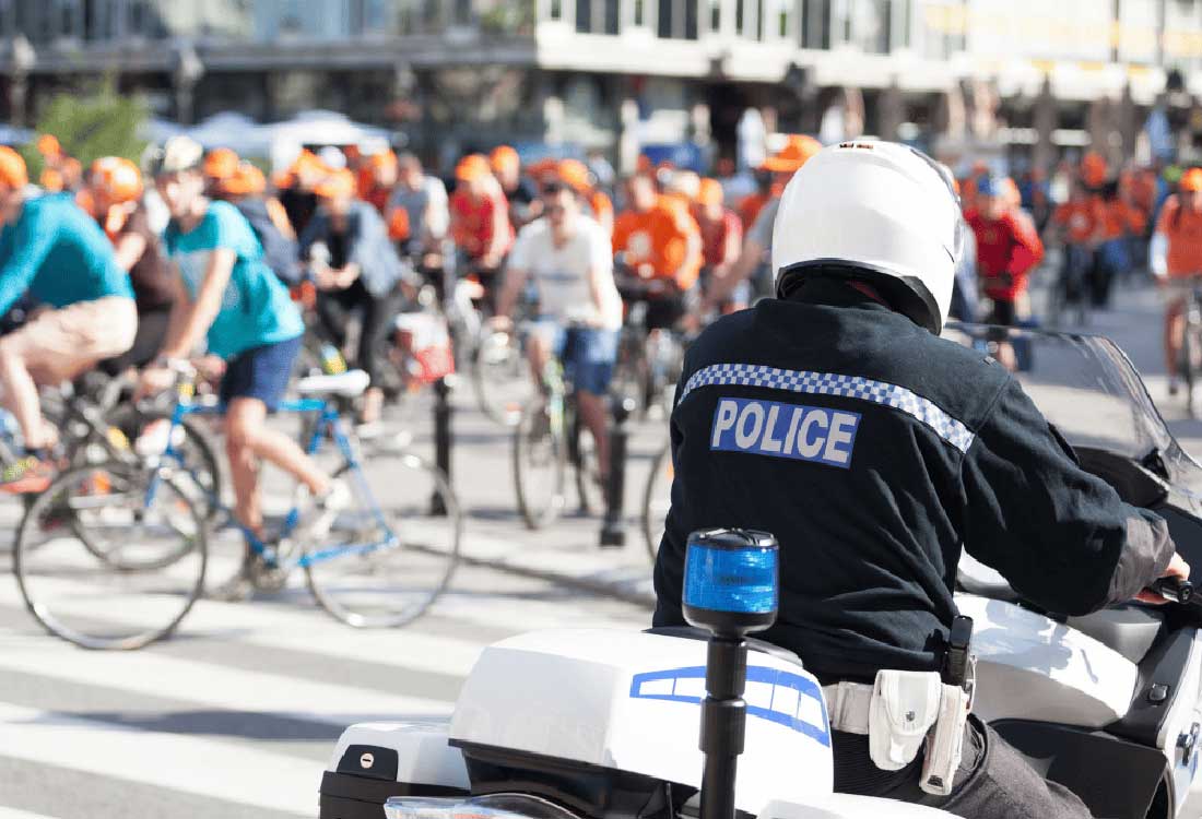 Auburn University at Montgomery campus police officer on motorcycle guides cyclists at community bike event