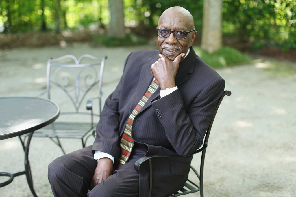 a man sitting in a chair talking on a cell phone