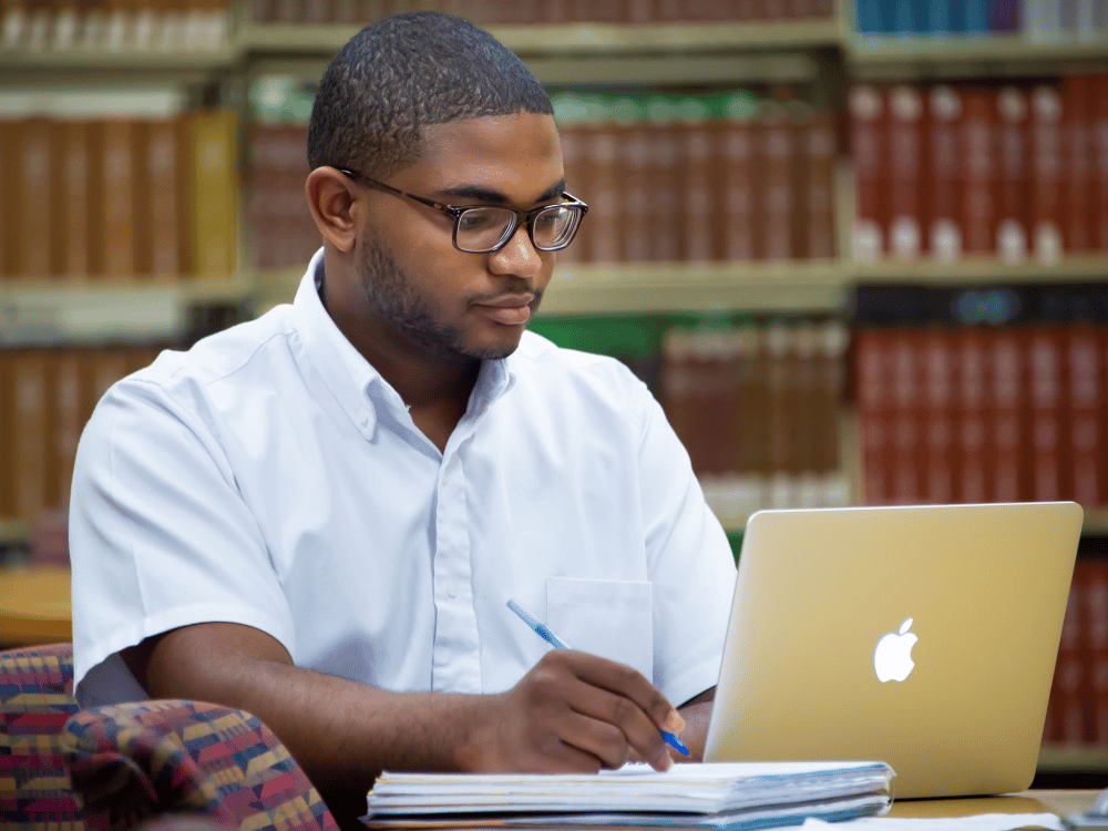a man sitting at a table using a laptop computer