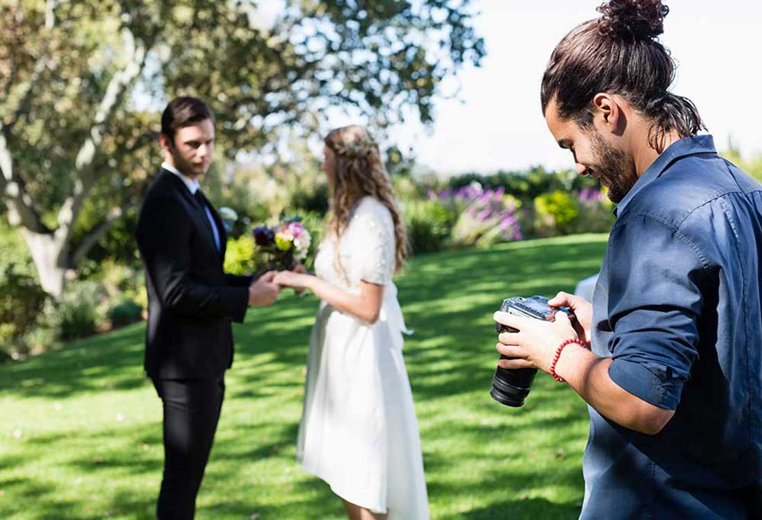 Photographer shoots a couple during an outdoor wedding ceremony on the Auburn University at Montgomery campus.