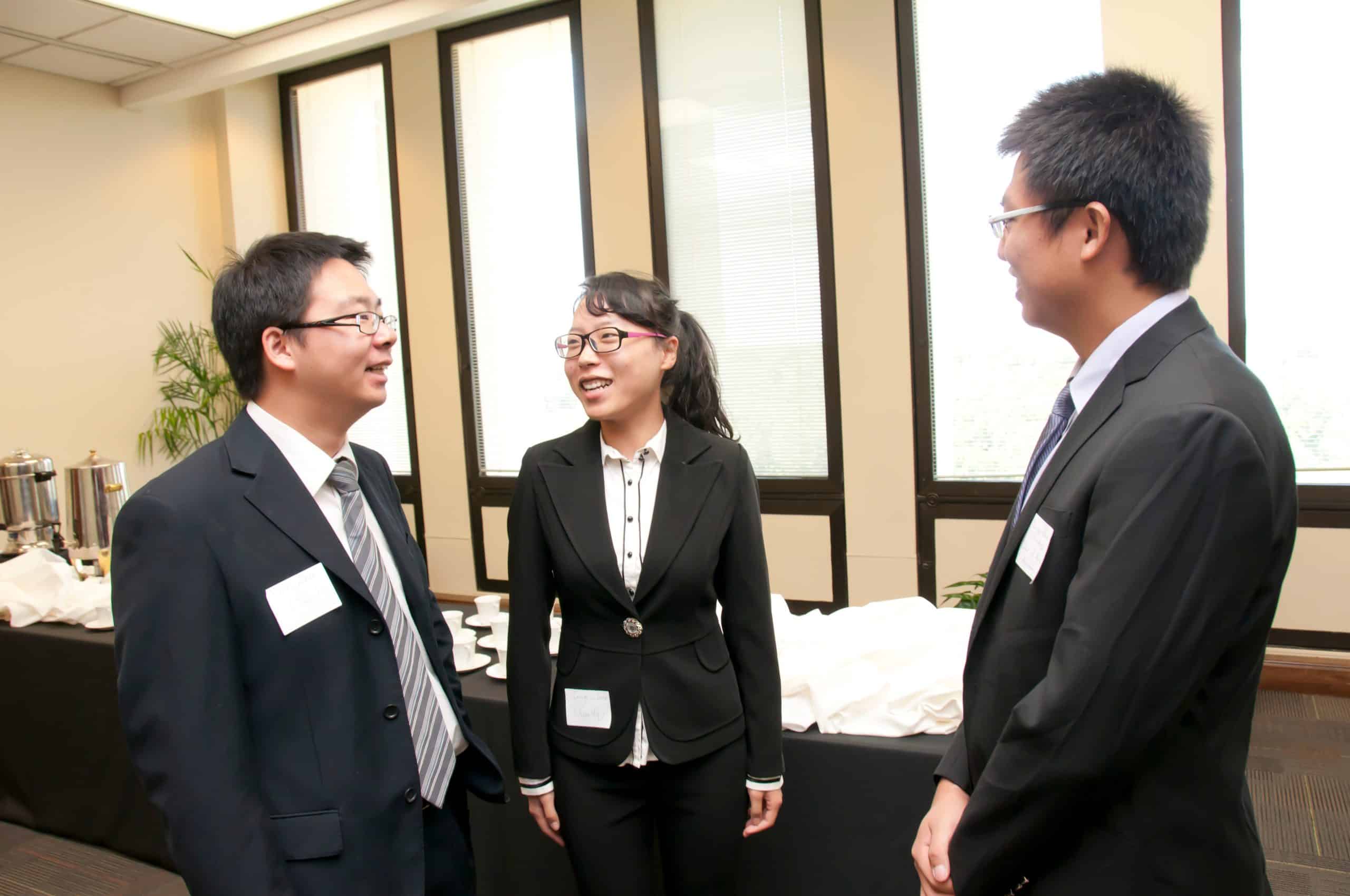 a man wearing a suit and tie standing next to a woman