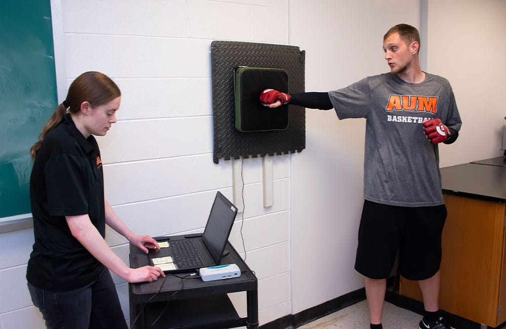 a man and a woman standing in front of a computer