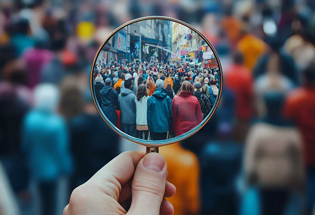 Auburn University at Montgomery research: a person holds a magnifying glass over a busy crowd, symbolizing data analytics.