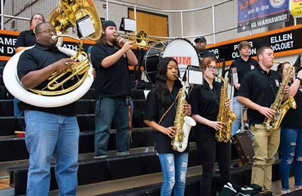 a group of people playing instruments and performing on a stage