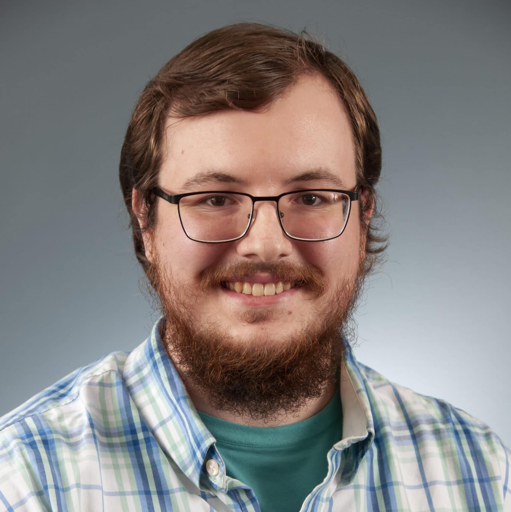 a man wearing glasses and smiling at the camera