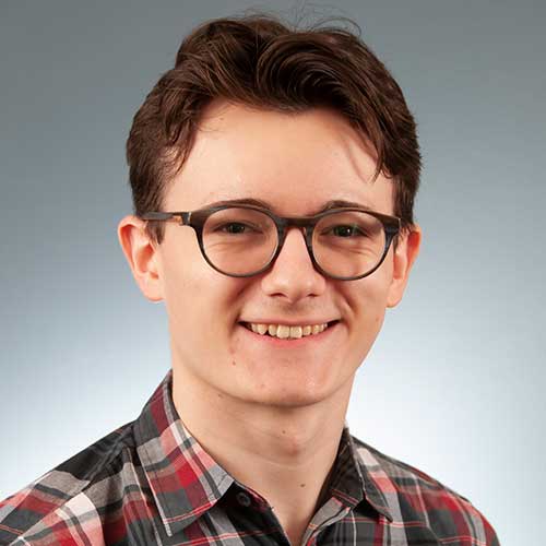 a man wearing glasses and smiling at the camera