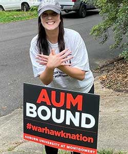 a person holding a sign on the side of a road